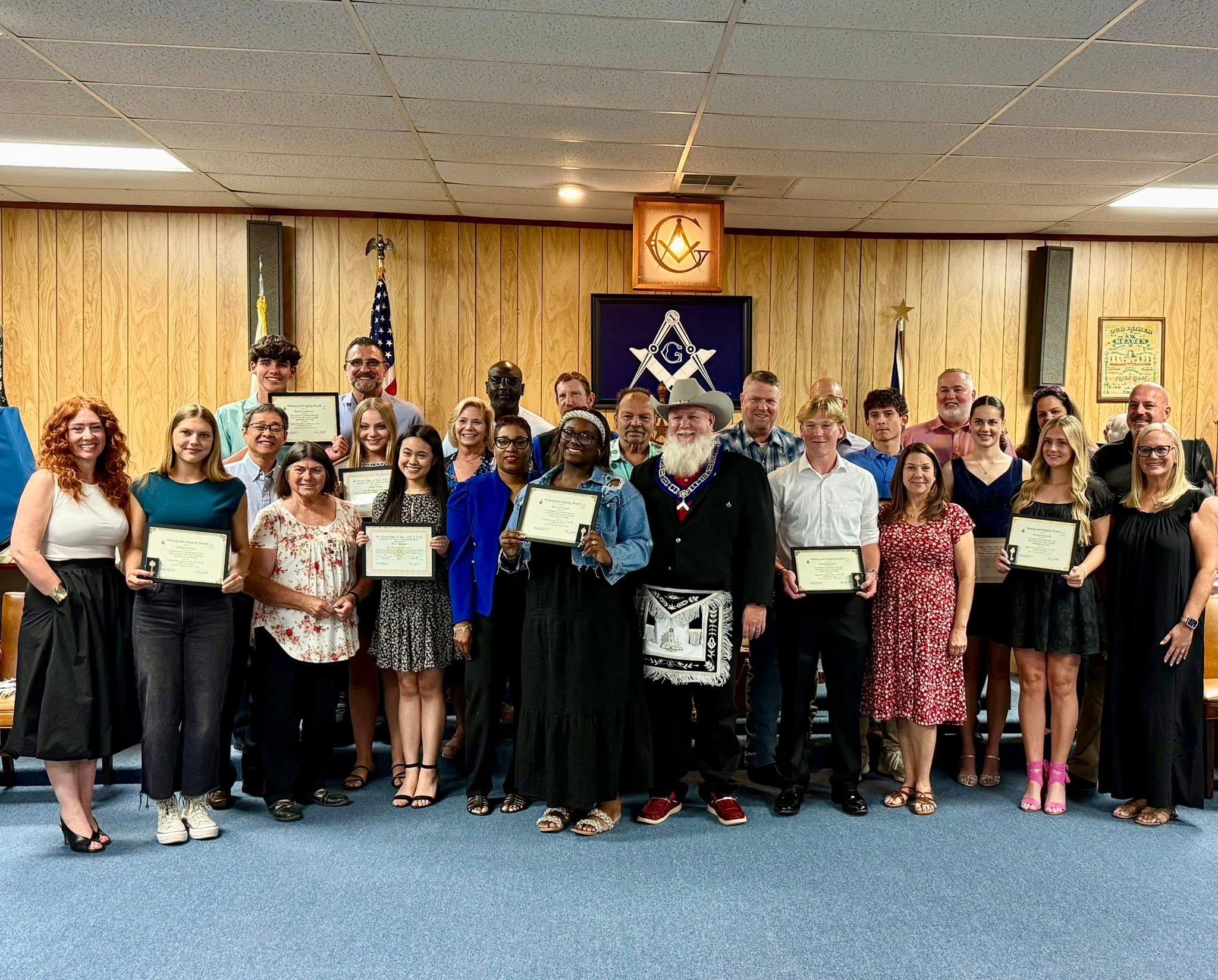 Lamar Scholarship recipients and their families with the Worshipful Master at the award ceremony in the League City Lodge room.